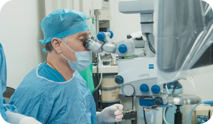 El Dr. Jairo Sánchez durante una cirugía oftalmológica con microscopio