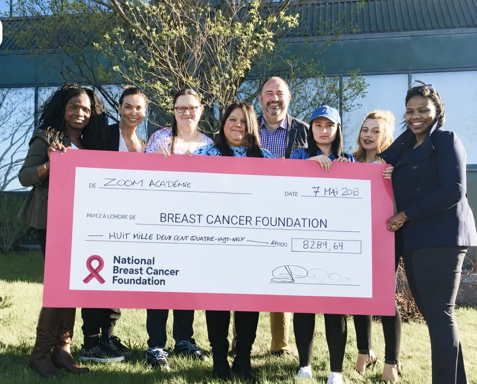 Zoom Academy graduates presenting a donation cheque